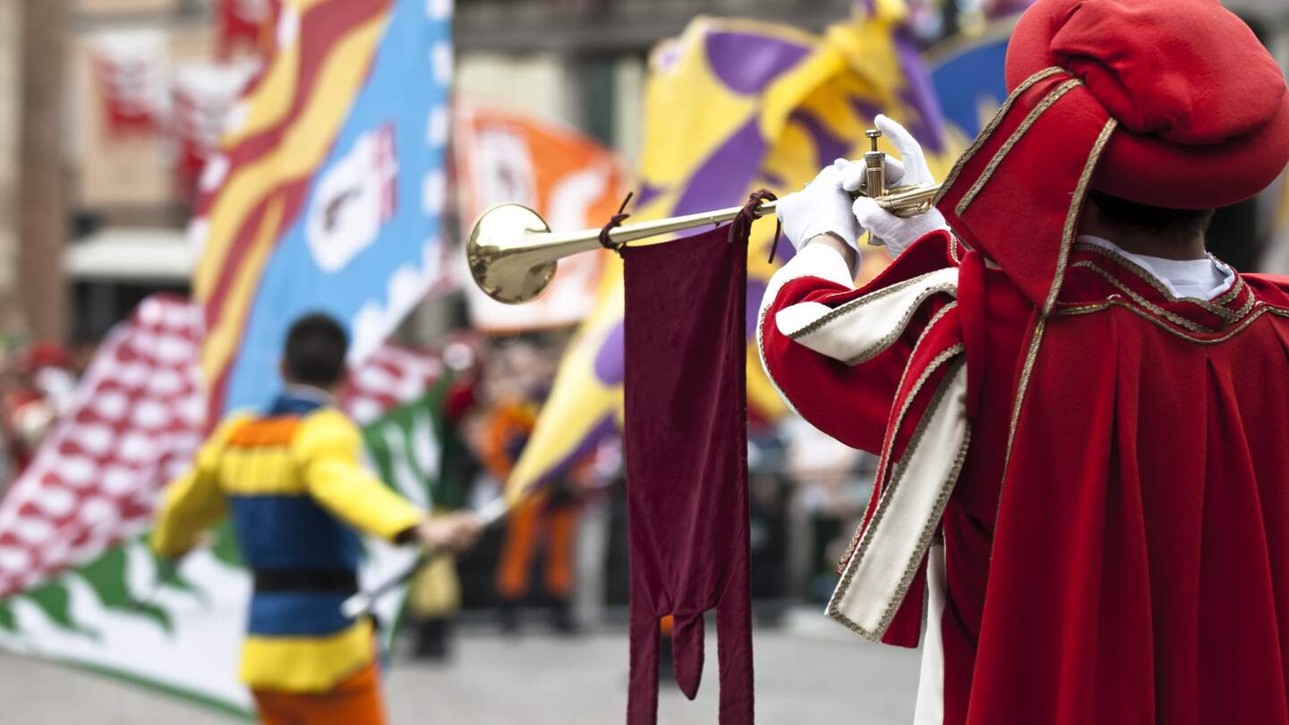 Traditionelles Pferderennen in der Innenstadt von Siena, die Flaggen symbolisieren die Stadtteile, die gegeneinander antreten | © Gettyimages.com/Flory