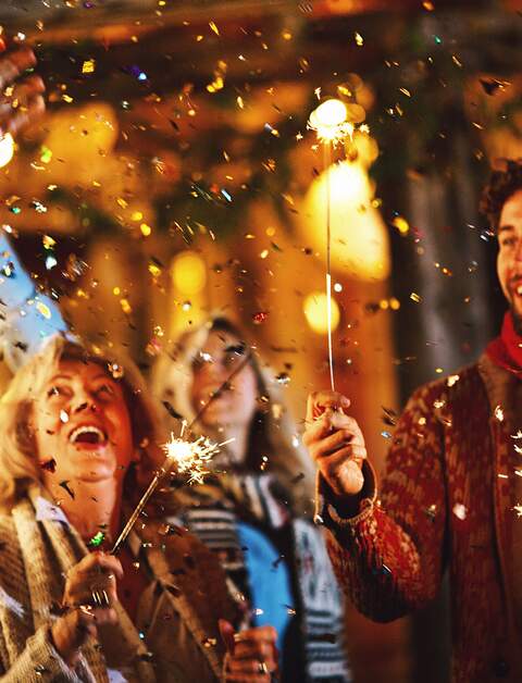 Eine Familie tanzt und feiert Silvester im Freien. | © Gettyimages.com/AjaKoska