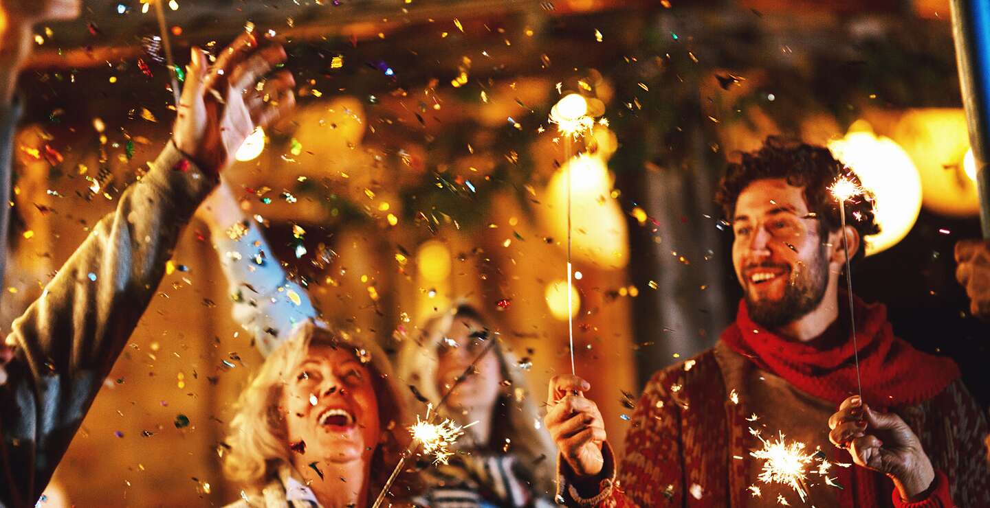 Eine Familie tanzt und feiert Silvester im Freien. | © Gettyimages.com/AjaKoska