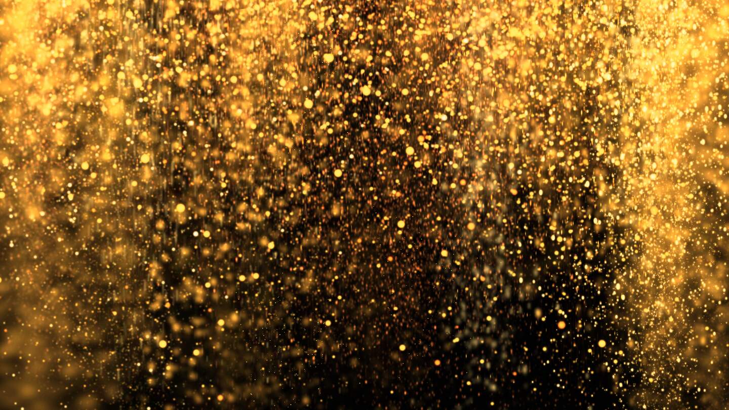 Goldener funkelnder Staub, der ueber den schwarzen Hintergrund faellt | © gettyimages.com/draganab