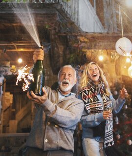  Ein älterer Mann oeffnete eine weitere Flasche Champagner und spritzte sie. | © Gettyimages.com/AjaKoska
