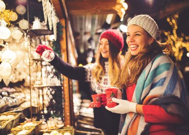Freundinnen auf dem Weihnachtsmarkt | © GettyImages.com/	M_a_y_a