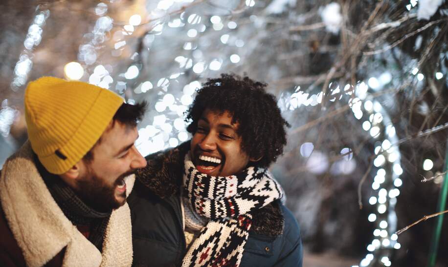junge maennliche Freunde, die sich in der Silvesternacht im Freien umarmen und lachen. | © Gettyimages.com/Aja Koska
