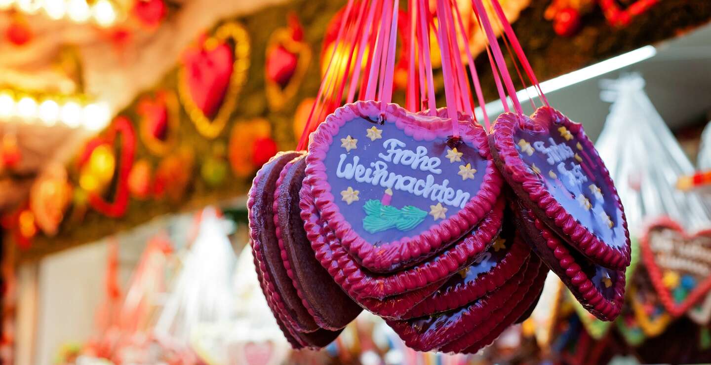 Markstand auf dem Weihnachtsmarkt und Lebkuchen Herzen | © Gettyimages.com/alethia97