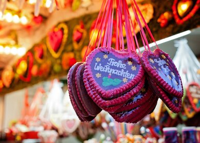 Markstand auf dem Weihnachtsmarkt und Lebkuchen Herzen | © Gettyimages.com/alethia97