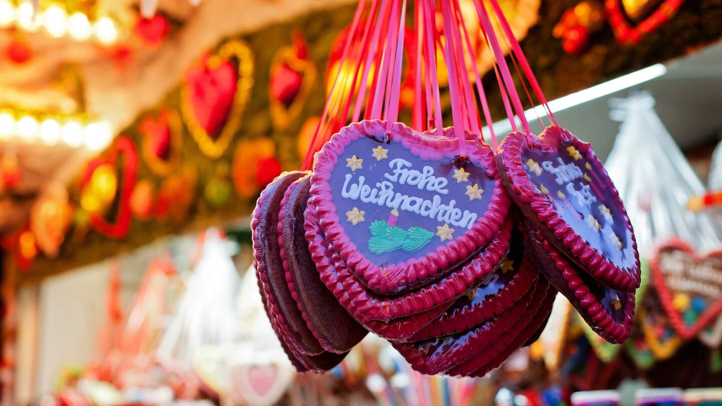 Markstand auf dem Weihnachtsmarkt und Lebkuchen Herzen | © Gettyimages.com/alethia97