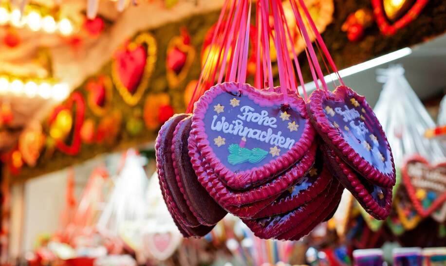 Markstand auf dem Weihnachtsmarkt und Lebkuchen Herzen | © Gettyimages.com/alethia97