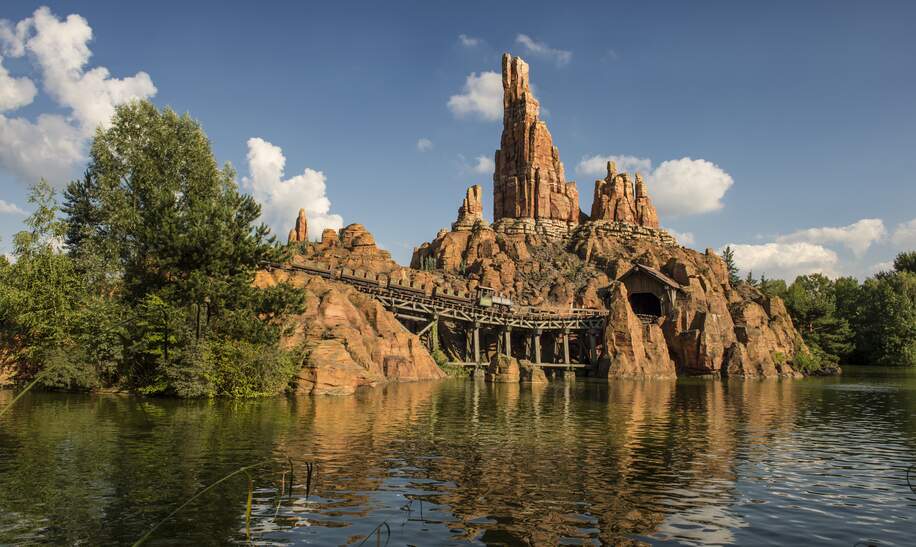 Die Attraktion Big Thunder Mountain. Im Vordergrund ein Gewässer. | © Disney