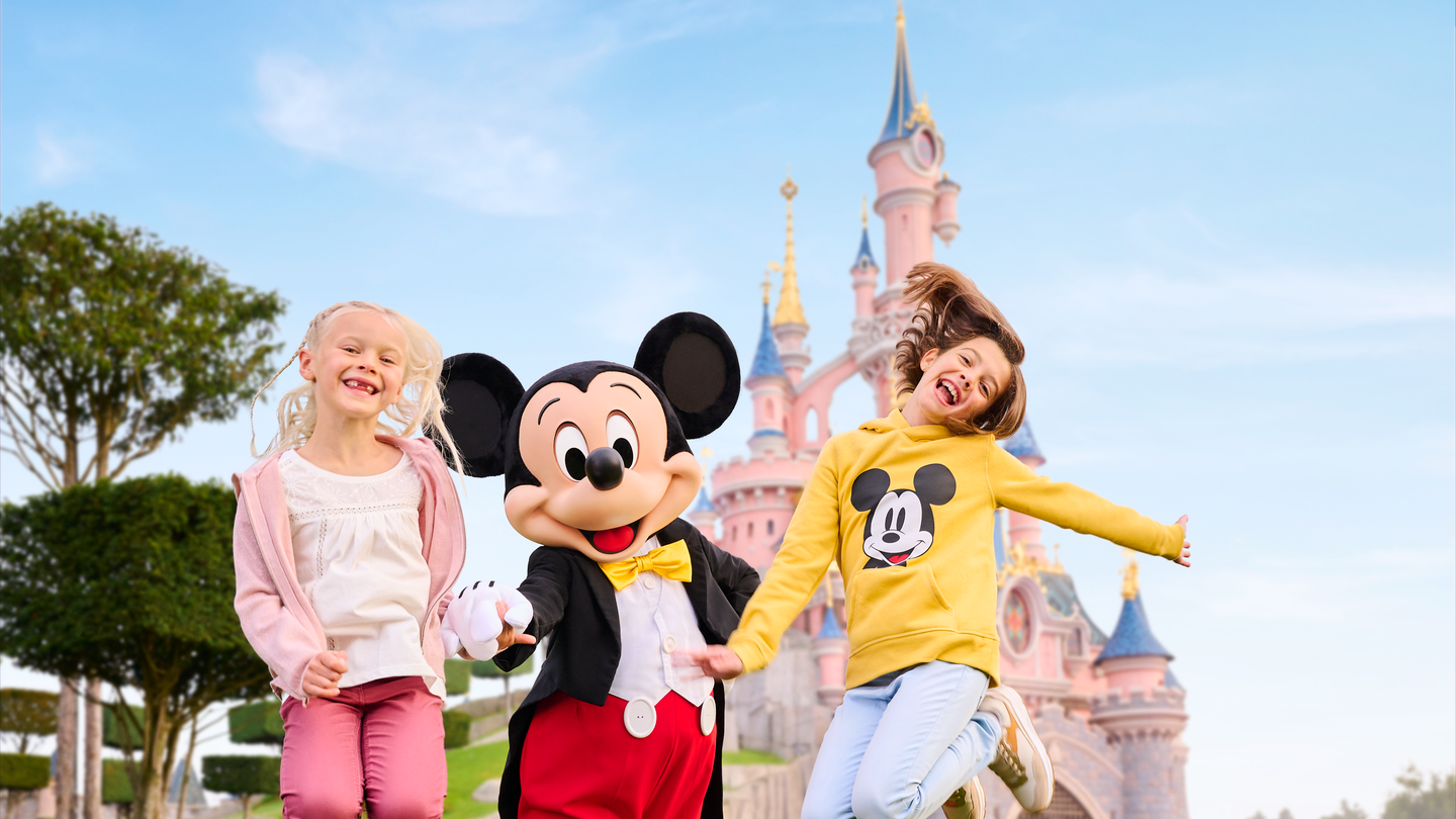 Micky Maus und zwei Kindern vor dem Sleeping Beauty Castle in Disneyland® Park | © Disney