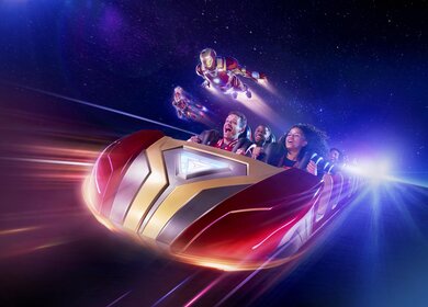 Personen sitzen in einem Wagen der Attraktion Avengers Assemble Flight Force in Disney Adventure World, mit ihnen fliegen Iron Man und Captain Marvel | ©  2024 MARVEL.