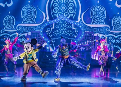 Disney Adventure World Musical Show Micky und der Zauberer, zu sehen sind zwei Taenzerinnen, Micky Maus und Genie aus Aladdin | © Disney