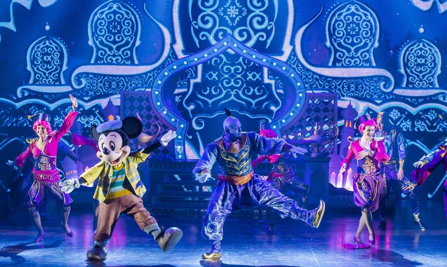 Disney Adventure World Musical Show Micky und der Zauberer, zu sehen sind zwei Taenzerinnen, Micky Maus und Genie aus Aladdin | © Disney