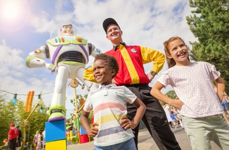 Walt Disney Studios Park Worlds of Pixar Buzz Lightyear Statue mit Cast Member und zwei Kindern | © Disney //2024 Pixar