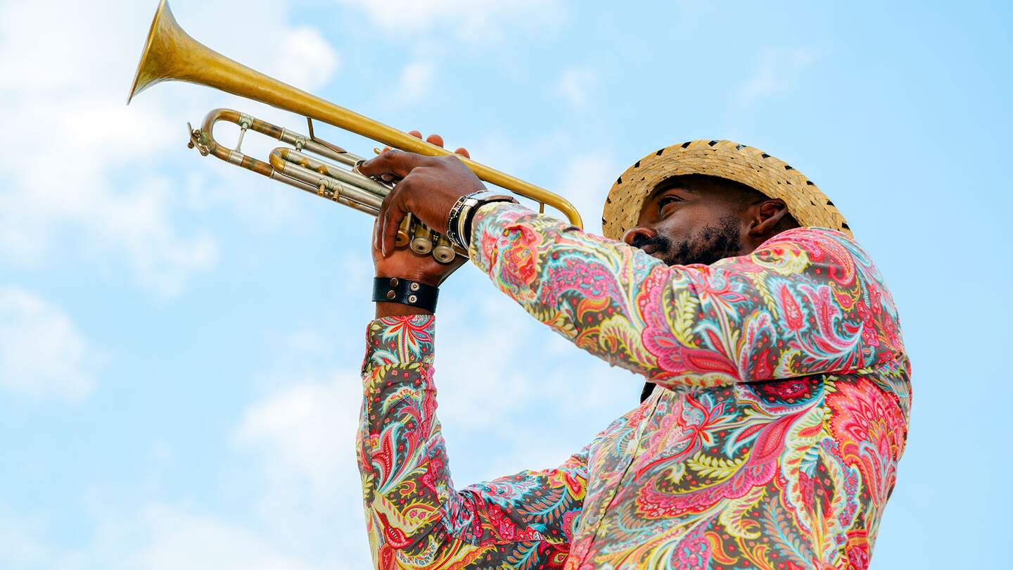 Kubanischer Musiker im bunten Hemd mit Trompete gegen blauen Himmel, Havanna, Kuba | © Gettyimages.com/Bim