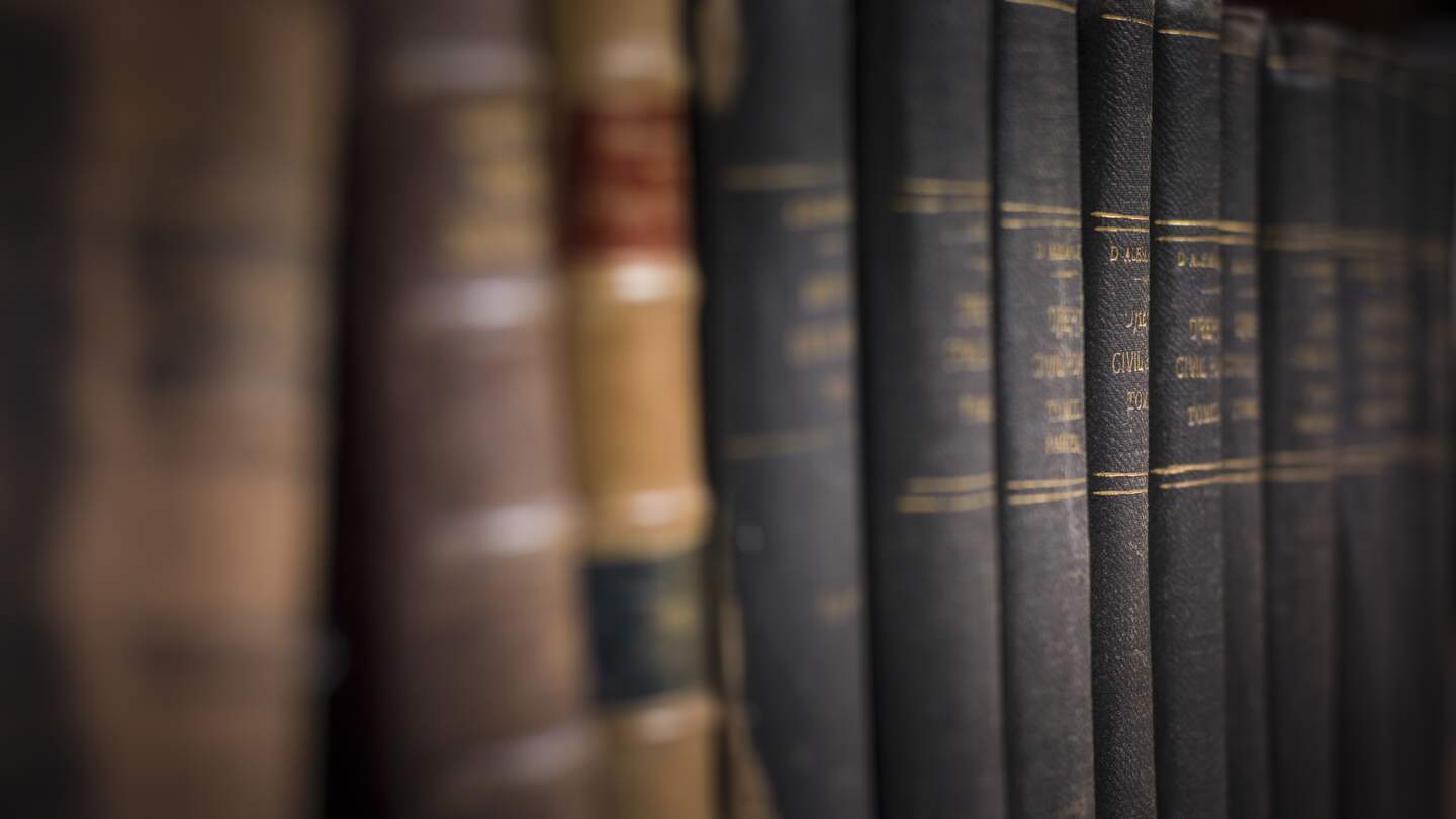 Eine Reihe alter Buecher im Dunkeln | © Gettyimages.com/thomaguery