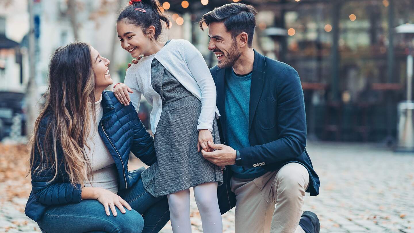 Familie, bestehend aus Mutter, Tochter und Vater lächeln während sie sich anschauen | © Gettyimages.com/pixelfit