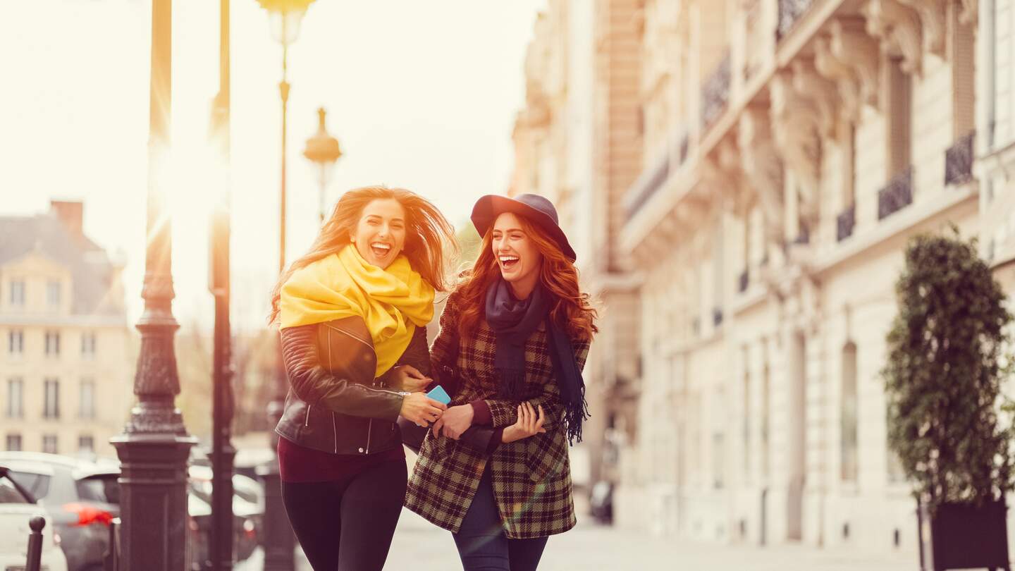 Freundinnen laufen im Herbst ueber die Strasse in Paris | © Gettyimages.com/martin-dm