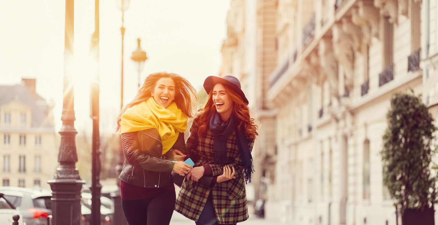 Freundinnen laufen im Herbst ueber die Strasse in Paris | © Gettyimages.com/martin-dm