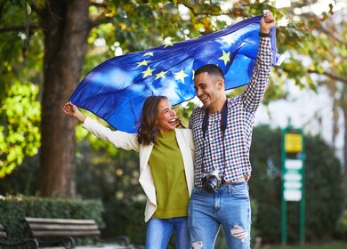 Touristenpaar EU-Flagge Staedtereise | © GettyImages.com/djiledesign