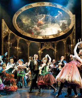 Ensemble des Musicals Das Phantom der Oper in aufwendigen Kostümen und Masken während einer großen Maskenball-Szene vor prunkvoller Bühnenkulisse. | © ATG ENTERTAINMENT GmbH/ UK Tour