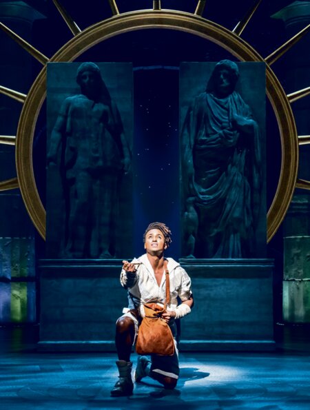 Disneys Hercules kniend auf der Bühne singt.  | © Stage Entertainment/Johan Persson 