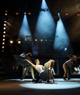 Szenenbild mit Celina dos Santos als Monika, Mathias Reiser als Freddy und Ensemble von KU’DAMM 59 - Berlins Hit-Musical geht weiter! | © Dominic Ernst