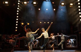 Szenenbild mit Celina dos Santos als Monika, Mathias Reiser als Freddy und Ensemble von KU’DAMM 59 - Berlins Hit-Musical geht weiter! | © Dominic Ernst