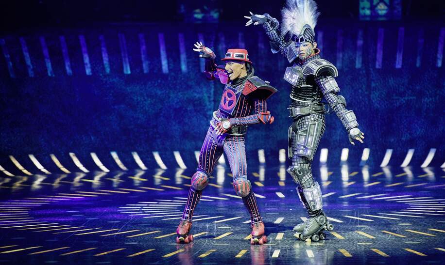 Szenenbild mit Irra Cenina als E-Lok Elecrta und Daniel Ellison als Bremswagen Caboose aus dem Musical Starlight Express | © Starlight Express/Detlef Overmann