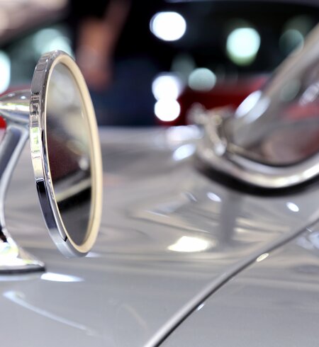 Nahaufnahme eines Spiegels eines silberfarbenen Mercedes-Benz 300  | ©  Gettyimages.com/vuk8691