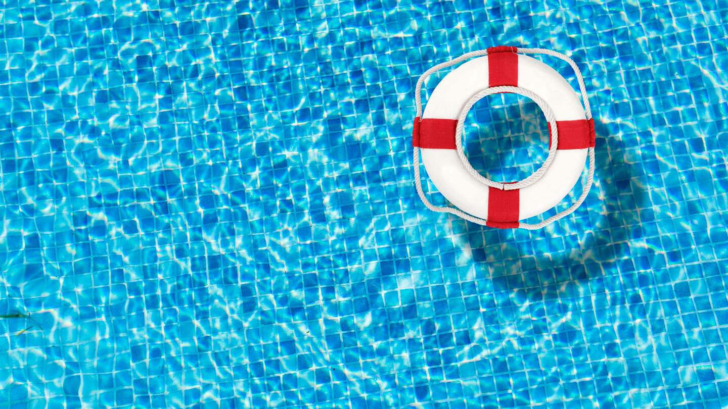 Rettungsring der in einem klaren Poolwasser schwimmt | © GettyImages.com/artisteer
