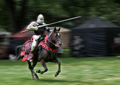 Mit einer Lanze bewaffneter Ritter greift im Galopp bei Ritterspielen an | © Gettyimages.com/bcreigh