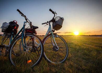 Zwei Fahrräder mit vollen Gepäckträgern auf dem Tempelhofer Feld in Berlin bei Sonnenuntergang  | © GettyImages.com/http://www.fotogestoeber.de