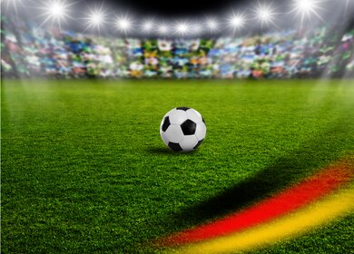 Public Viewing Fussball 2024 Flyer mit Fussball im durch Scheiwerfer beleuchteten Stadion  | © Gettyimages.com/by-studio