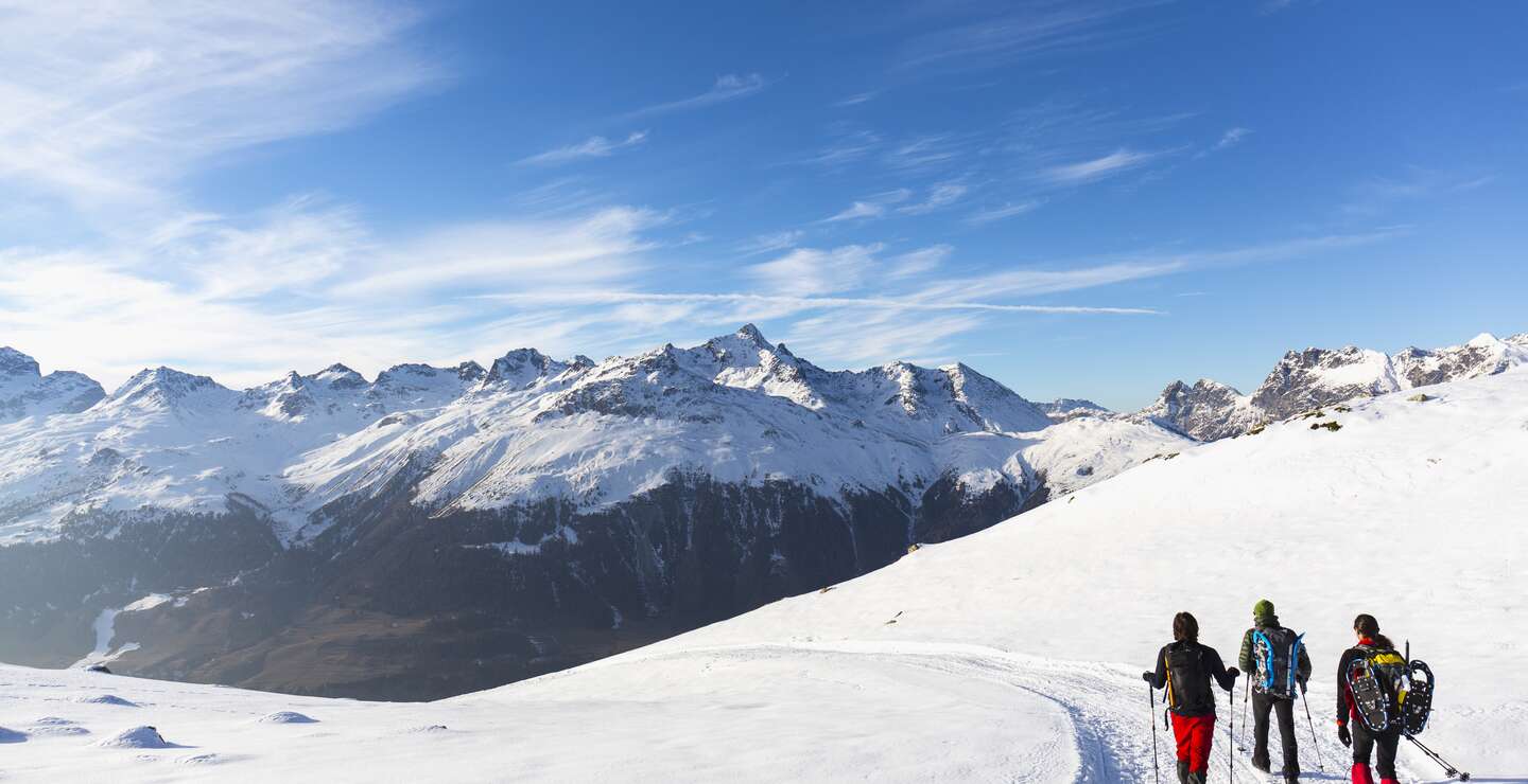 Wanderer wandern auf schneebedeckter Strasse im Hochgebirge | © Gettyimages.com/deimagine