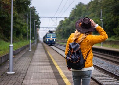 Frau mit Rucksack und Hut, die mit dem Zug reist. | © Gettyimages.com/ZbynekPospisil