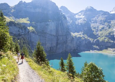 Zwei Personen wandern im Sommer in einer wunderschoenen Alpenlandschaft in den Schweizer Alpen | © Gettyimages.com/Mystockimages