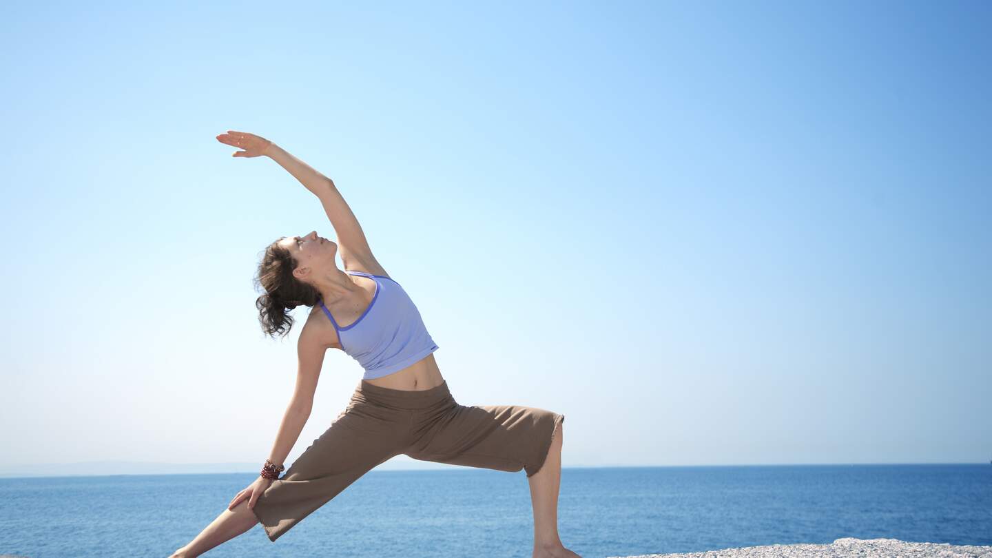 junges Maedchen macht allein am Meer Yoga-Uebungen. | © Gettyimages.com/Casarsa