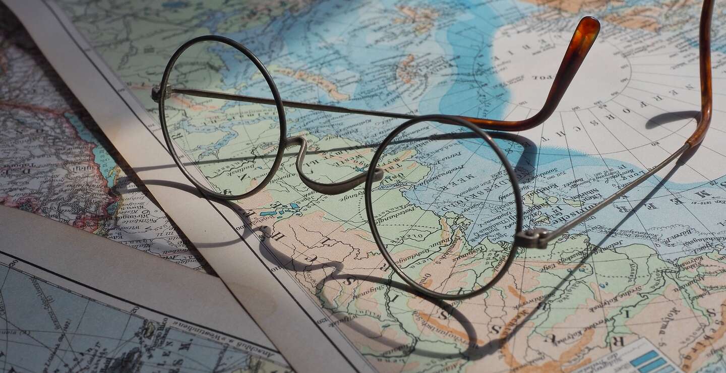 Brille liegt auf mehreren Weltkarten und wirft einen Schatten auf sie | © Pixabay/beasternchen