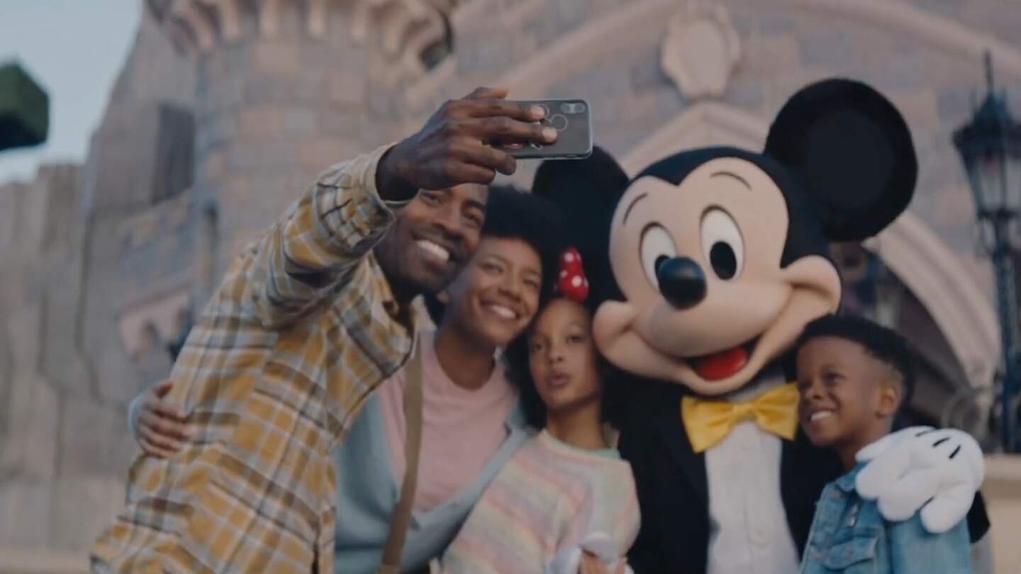 Mickey Mouse macht ein Selfie mit Parkgästen | © DISNEY
