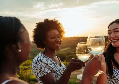 Drei Maedchen mit Glaesern Weisswein stossen auf die Freundschaft an | © Gettyimages.com/Dimensions