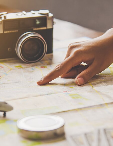 Reisende planen eine Reise, indem sie die Route auf der Karte | © Gettyimages.com/Photobyphotoboy