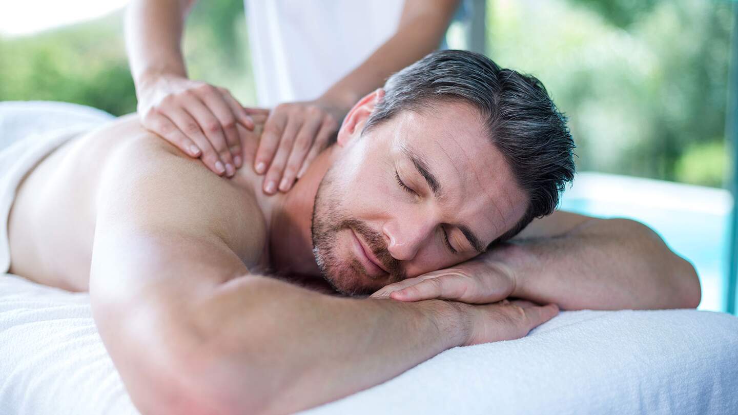 Mann bekommt eine Rückenmassage von einem Masseur | © Gettyimages.com/Wavebreakmedia