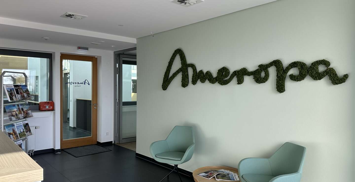 Empfang des Unternehmens Ameropa mit zwei türkisfarbenen Stühlen und einem kleinen Tisch dazwischen. | © Ameropa Reisen 