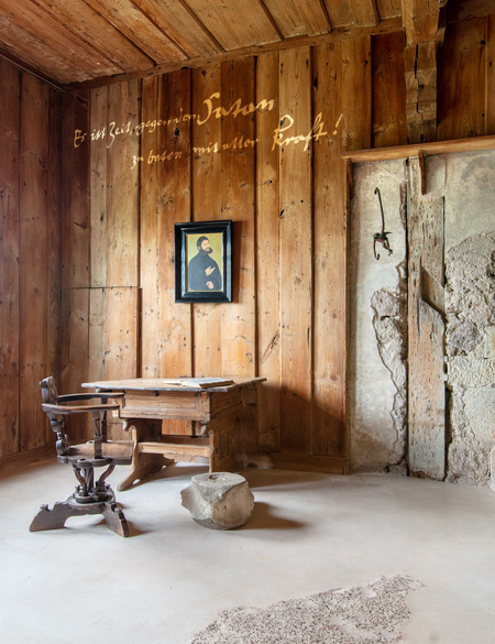 Wartburg Zimmer mit altem Holzschreibtisch und Stuhl mit Kamin | © ©Andreas Matthes, Wartburg-Stiftung / KOCMOC