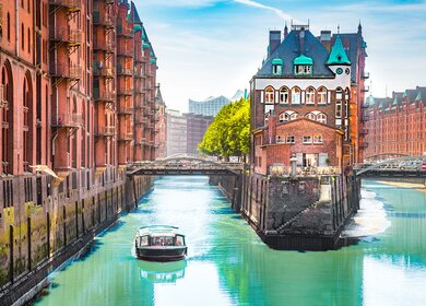 Speicherstadt in Hamburg mit einem Tourboot auf dem Wasser | © gettyimages.com