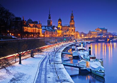 Beleuchtete Altstadt an der Elbe in einer Winternacht mit Schnee | © GettyImages.com/aletheia97
