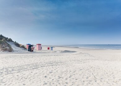 Strandkoerbe auf der Insel Borkum mit Sand und ein blauer Himmel | © Gettyimages.com/tobiasschwarz Strandkoerbe auf der Insel Borkum mit weissem Sand und ein blauer Himmel | © Gettyimages.com/tobiasschwarz