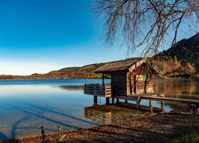 Holzhuette am Schliersee | © Pixabay.com/RobbyFo  ruhige See mit einer Holzhuette auf einem Steg, der in das ruhige Wasser des Schliersees ragt | © Pixabay.com/RobbyFo