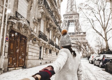 Frau läuft zu Fuß zum Eiffelturm mit Schnee im Winter in Paris. | © Gettyimages.com/Orbon Alija