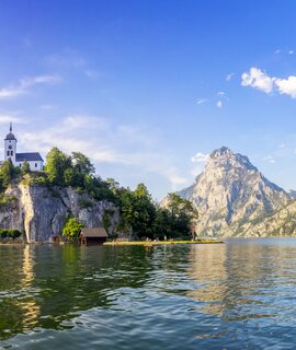 Im Vordergrund ist der See, doch im Zentrum steht die Kapelle auf dem Berg | © Gettyimages.com/dietermeyrl